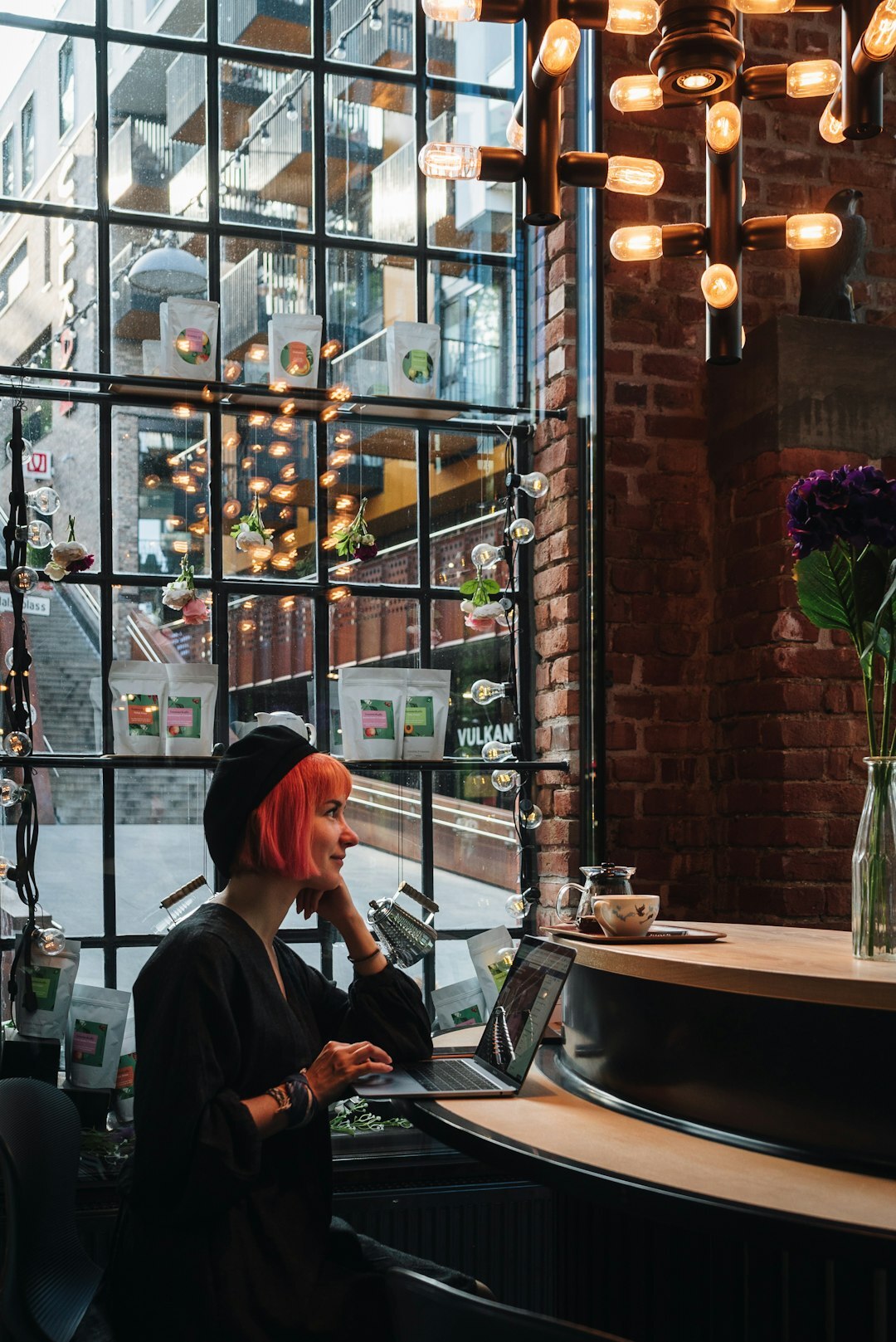 Scandinavian woman writing notes on a laptop in a cozy cafe