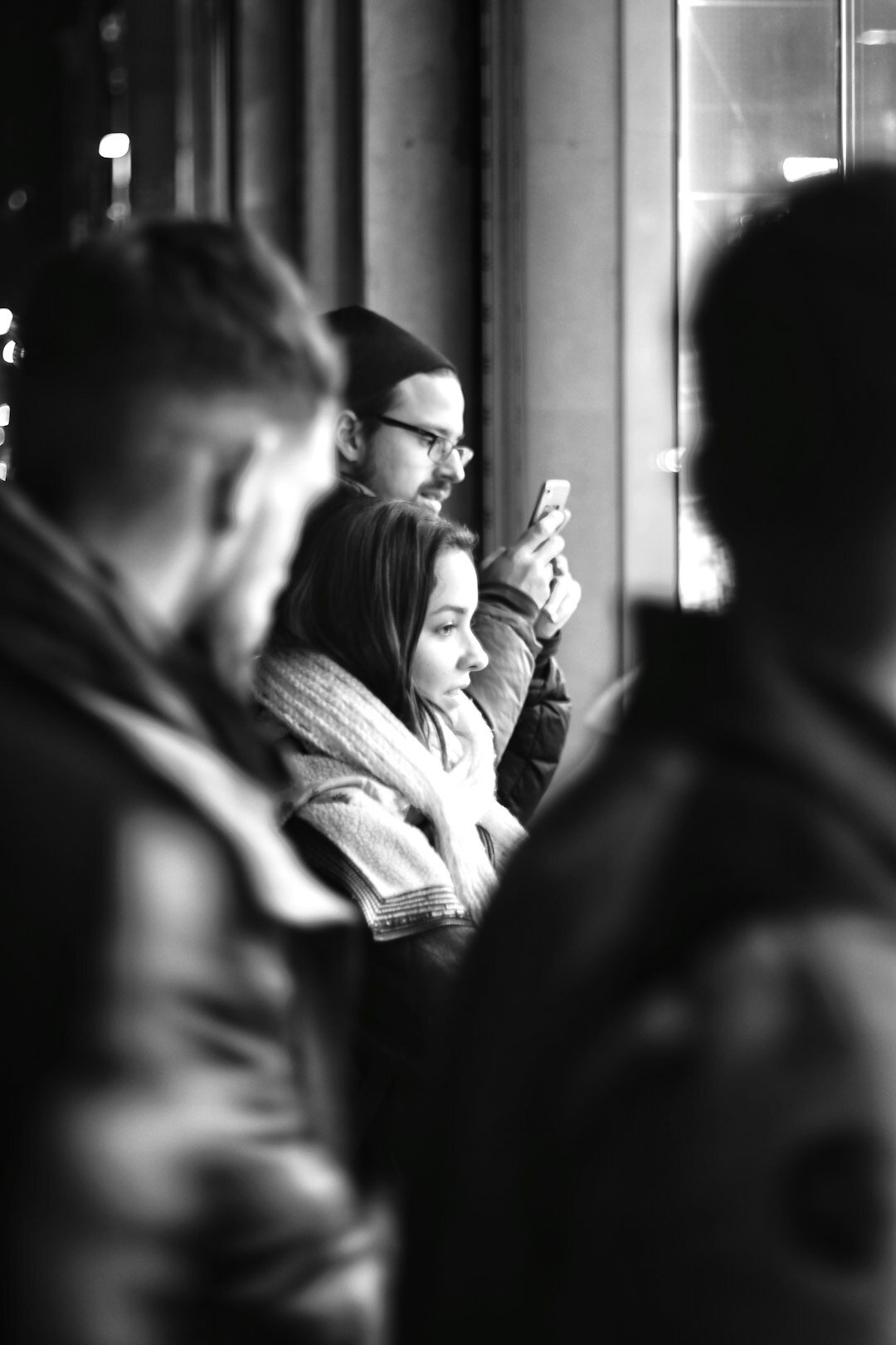 Group of friends of different ages drinking coffee and talking by a window